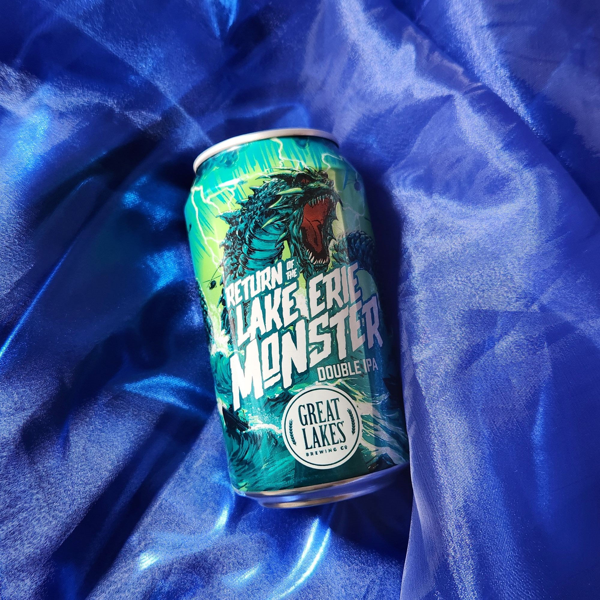 12 oz. Can of Return of the Lake Erie Monster Double IPA laid upon wavy blue fabric.