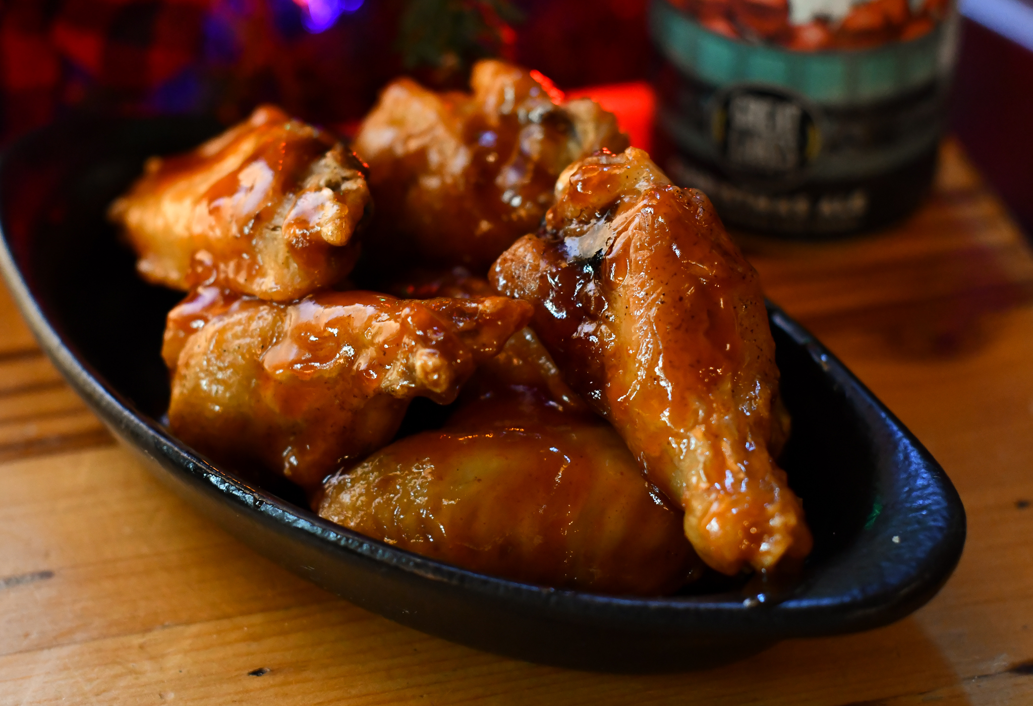 Chipotle glazed chicken wings next to a can of Christmas Ale.