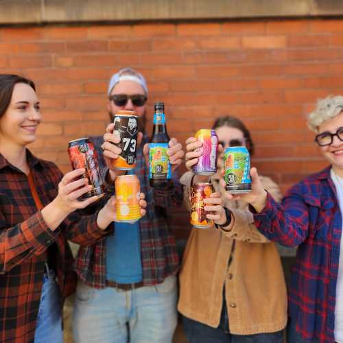 A group of people in fall clothes toasting with Great Lakes beers